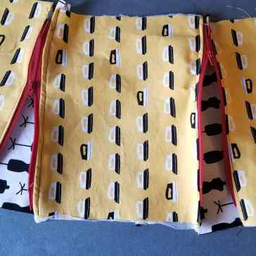 [Image: Yellow side panels with red zippers spread out with white and black lining showing.]